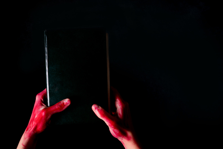 Alchemy book with bloody hand. halloween concept