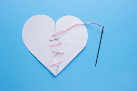Healing broken heart. needle with pink threadの写真素材