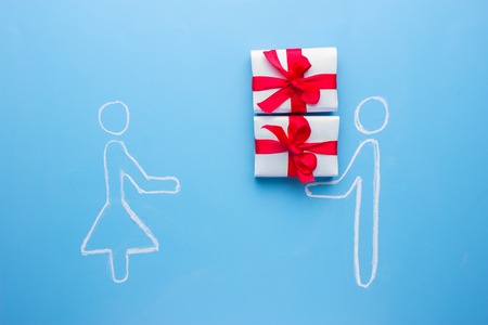 men give a box with red bow with present for womenの写真素材