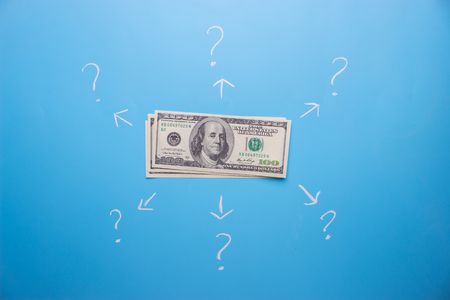 money with arrow and question mark. on what to spend money conceptの写真素材