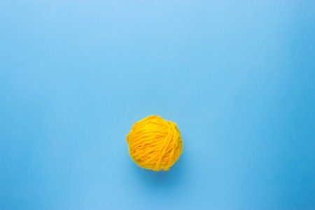 yellow Ball of wool cotton on blue backgroundの写真素材