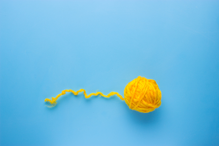 yellow Ball of wool cotton on blue backgroundの写真素材