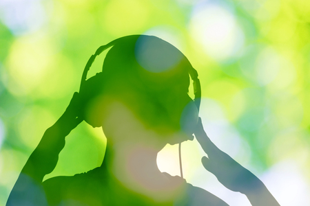 sihouette of a girl listening to relax music on nature backgroundの写真素材