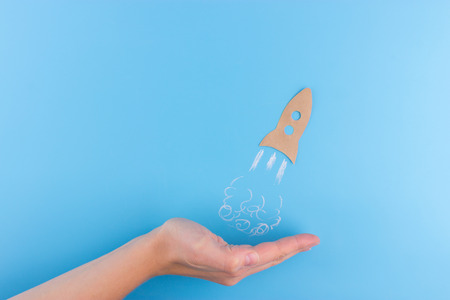 rocket made from paper on blue background. business concept