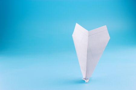 plane crash concept. paper plane upside down on blue backgroundの写真素材