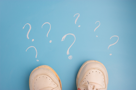 sneaker on blue background Surrounded by question marksの写真素材