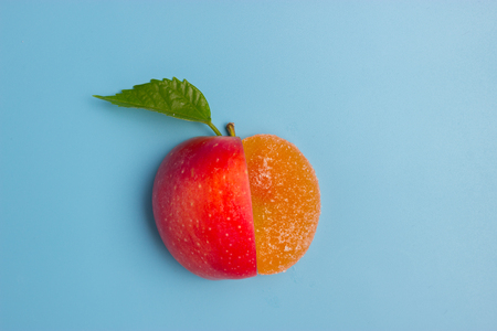 half of an apple and sweet food. unhealthy vs healthy foodの写真素材