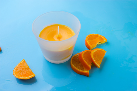 orange aroma candle on the blue backgroundの写真素材