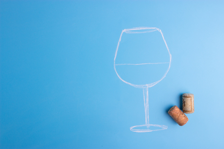 glass of wine with a corkscrew on blue backgroundの写真素材