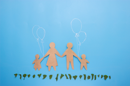 paper family on blue background and green grassの写真素材
