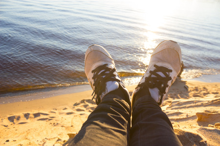 Young girl laying near the lake and resting. sunsetの写真素材