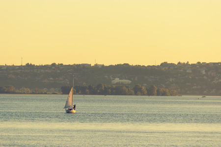 Sail Boat on a river. yellow sunlightのeditorial素材