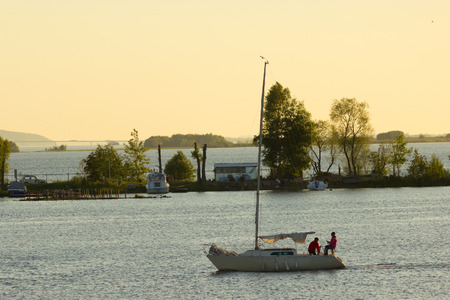 small Sailing boat in a warm sunset lightのeditorial素材