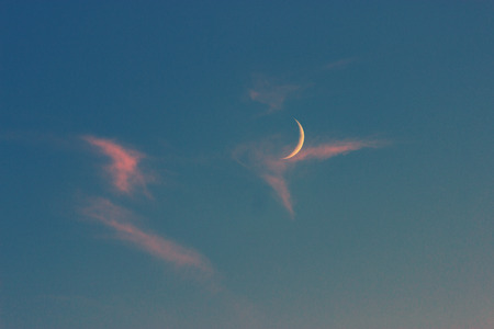 moon on a blue sky with pink cloudsの写真素材