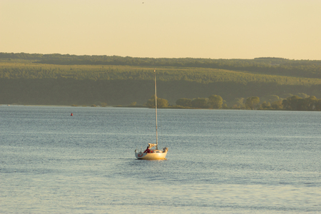 small Sailing boat in a warm sunset lightのeditorial素材