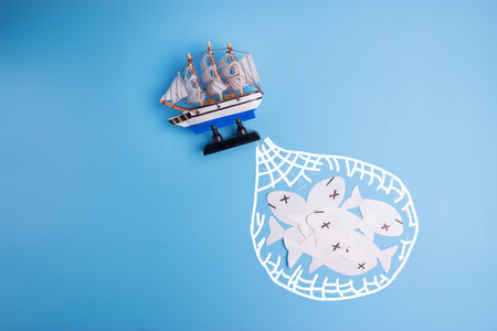 ocean is overfished concept image. paper fish and toy ship