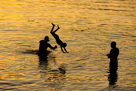 child and adults playing in water. unrecognizable silhouetteの写真素材