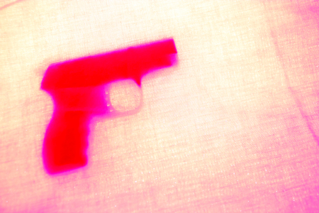 handgun behind pink curtain. close up. soft focusの写真素材