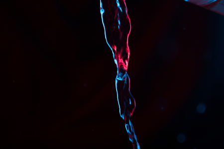 Red and blue neon background from water flow. defocused