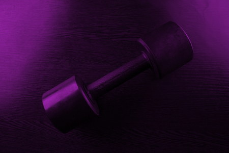 metal barbell on dark background in neon lightの写真素材