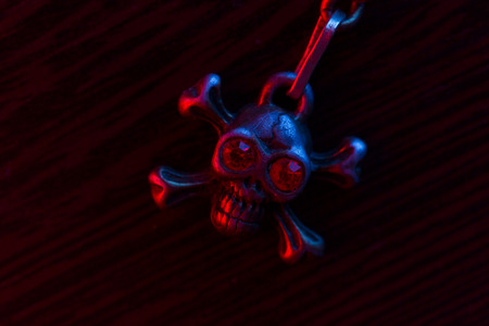 Metal skull chain in neon red and blue lightの写真素材