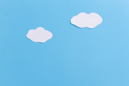 white clouds painted on blue bacground. paper cutの写真素材