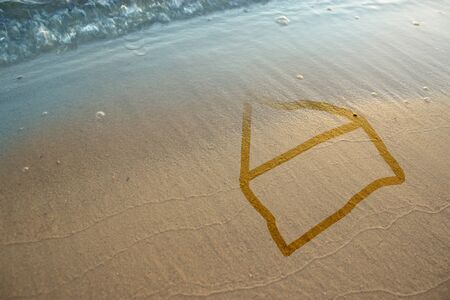 Wave wanishing house on sand. Flood concept imageの写真素材