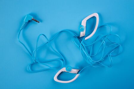 Blue headphones on blue background. Close upの写真素材