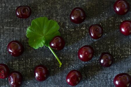 Fresh cherry on black background. Flat lay