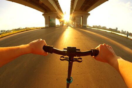 Scootet on road. Woman riding scooter. Sunlight. Extreme sportの写真素材