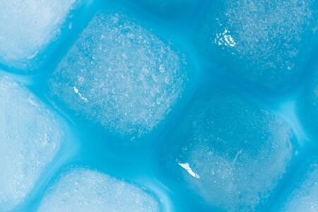 Melting ice cubes background on blue backgroundの写真素材