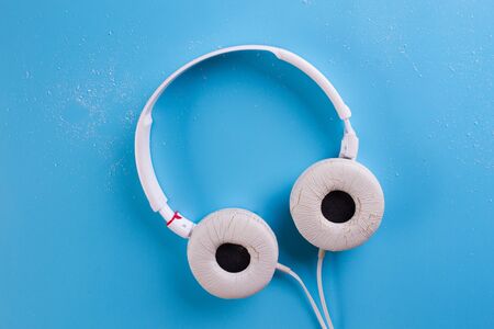 white headphones on the blue background. Flat lay