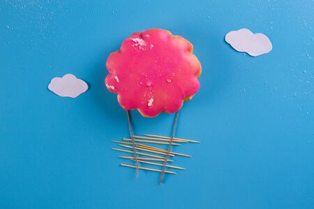pink cookie as airballoon on blue backgroundの写真素材