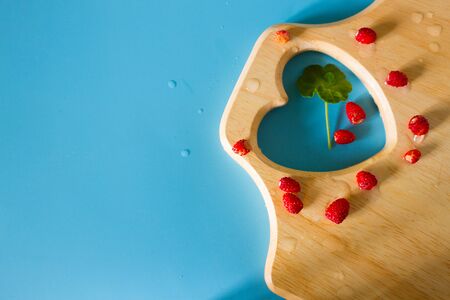 Harvest fresh red wild strawberries on cutting board