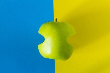 One green apple on the colorful backgroundの写真素材