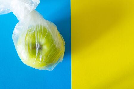Green apple in plastic bag. evironment pollution concept