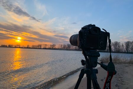 SLR camera on sunset background. Photography concept