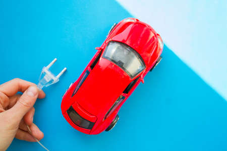 Electric car concept. Toy car and electric plug
