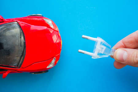 Electric car concept. Toy car and electric plug