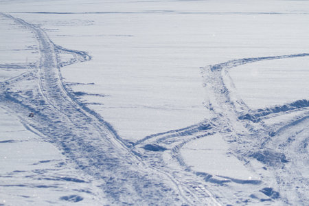 Snowmobile track marks on the snow of frozen riverの写真素材