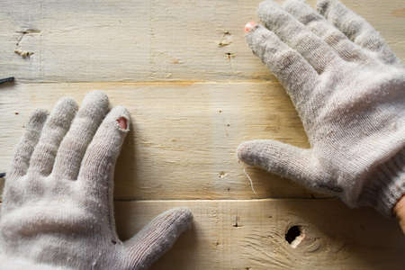 Hands in work gloves on wooden tableの写真素材