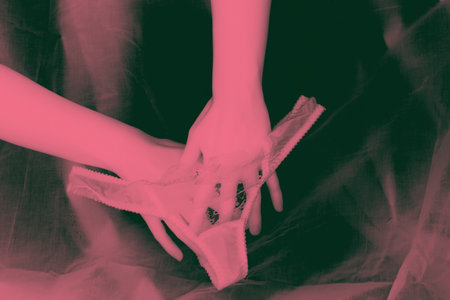 Masturbation concept image. Woman hands and panties in pink lightの写真素材