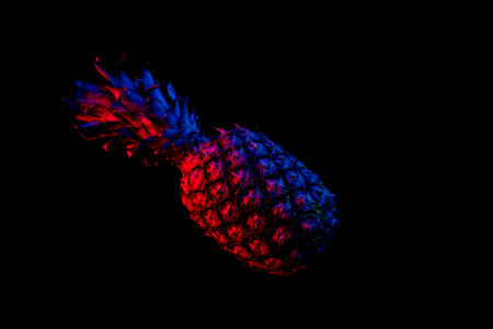 Pineapple in dark neon color on black backgroundの写真素材