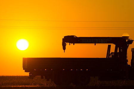 Silhouette of scaffold truck against sunlight