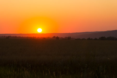 The sun going down over the fieldの写真素材