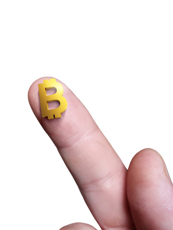 Micro sign Bitcoin electronic money on the finger and a white backgroundの写真素材