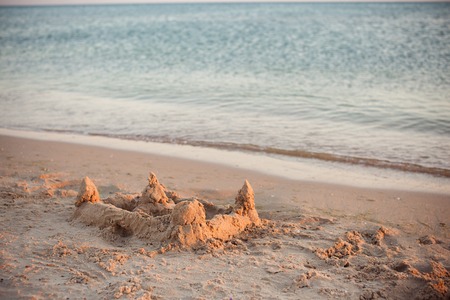 sand castle on the beach, lit by the setting sunの写真素材