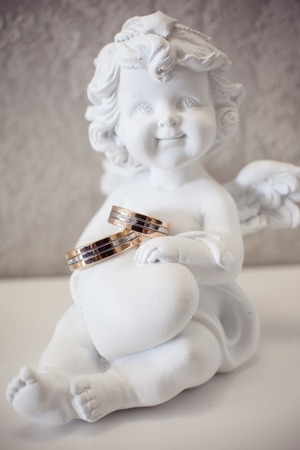 Figurine of an angel with wedding ringsの写真素材