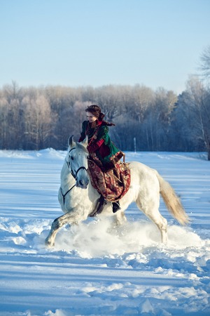 Girl riding a horse in winterの写真素材