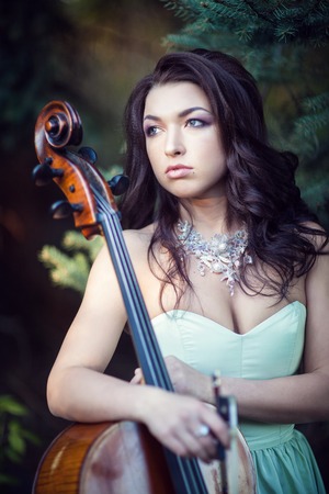 Girl in a green dress with a cello